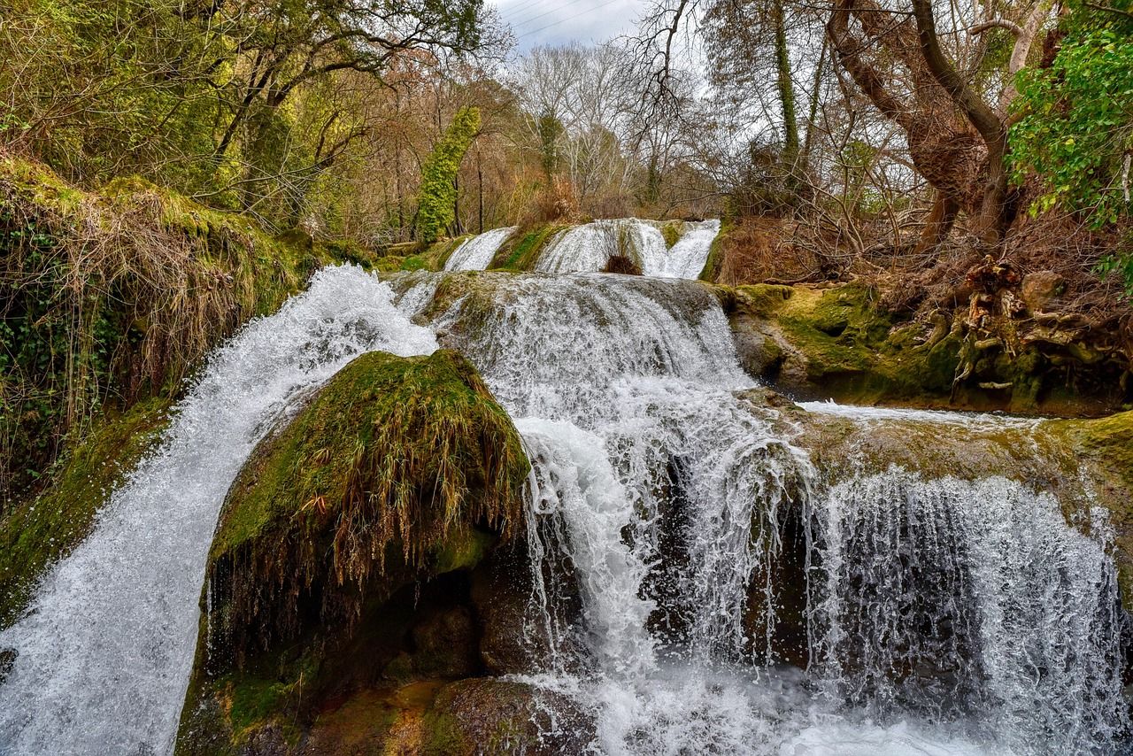Cachoeira descendo em degraus sobre pedras cobertas de musgo