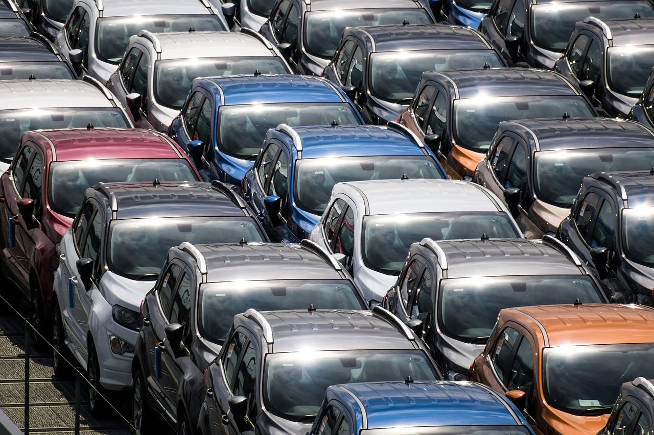 Pátio cheio de carros de várias cores, vistos de cima