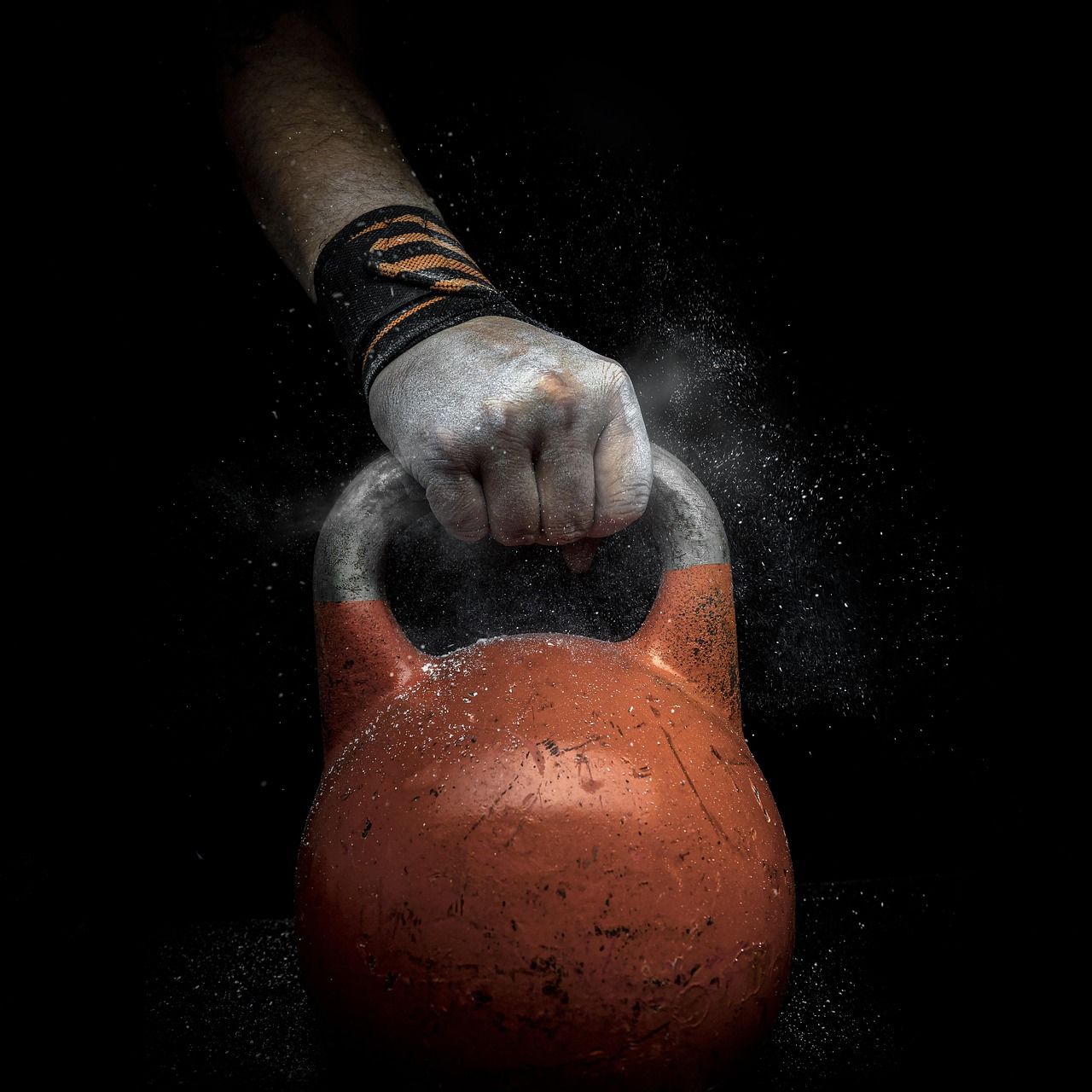 Mão com magnésio segurando a alça de um kettlebell