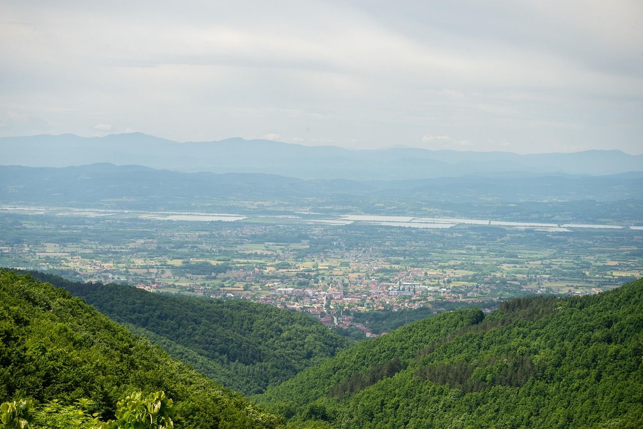 Vista do alto da serra para o vale, com morros cobertos de mata